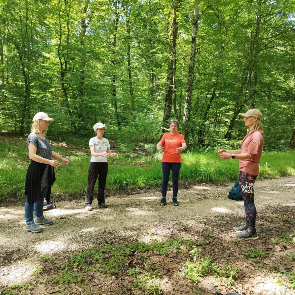 Quatre personnes en pleine nature, pendant une séance de souffle en forêt